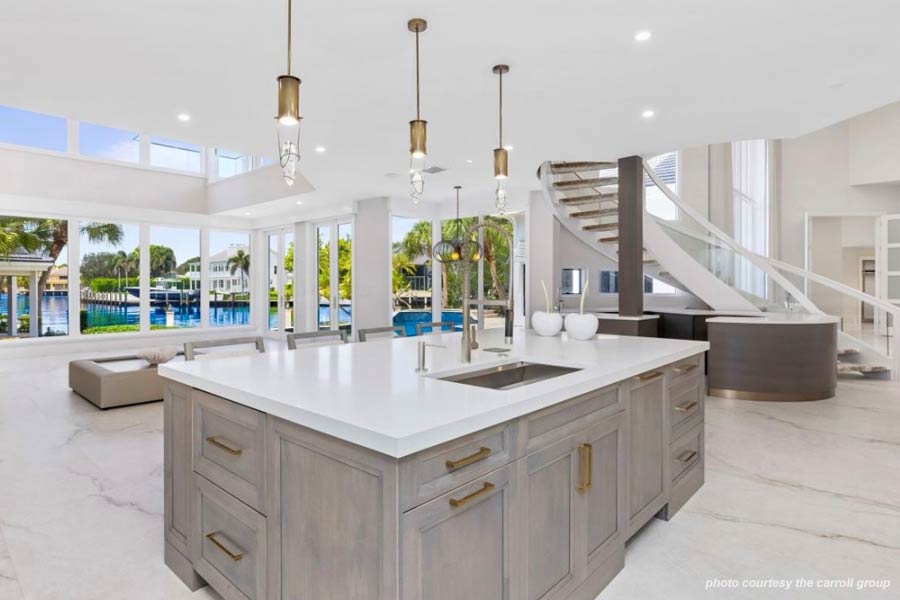 A massive Quartzite-topped island, the main area for meal preparation, is gracefully lit by Italian Murano blown pendants with antique brass light cylinders