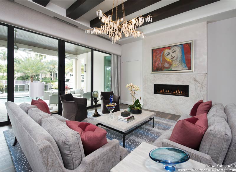 The focal point of the room, a two-sided linear gas fireplace opens to both the living room and club room.An orginal Jamali painting is installed above.