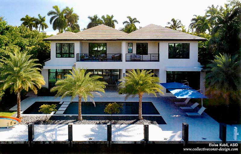 Aerial shot of the rear of the property highlights a serene integration of lush Florida landscaping, spacious deck, swimming pool, dock.
