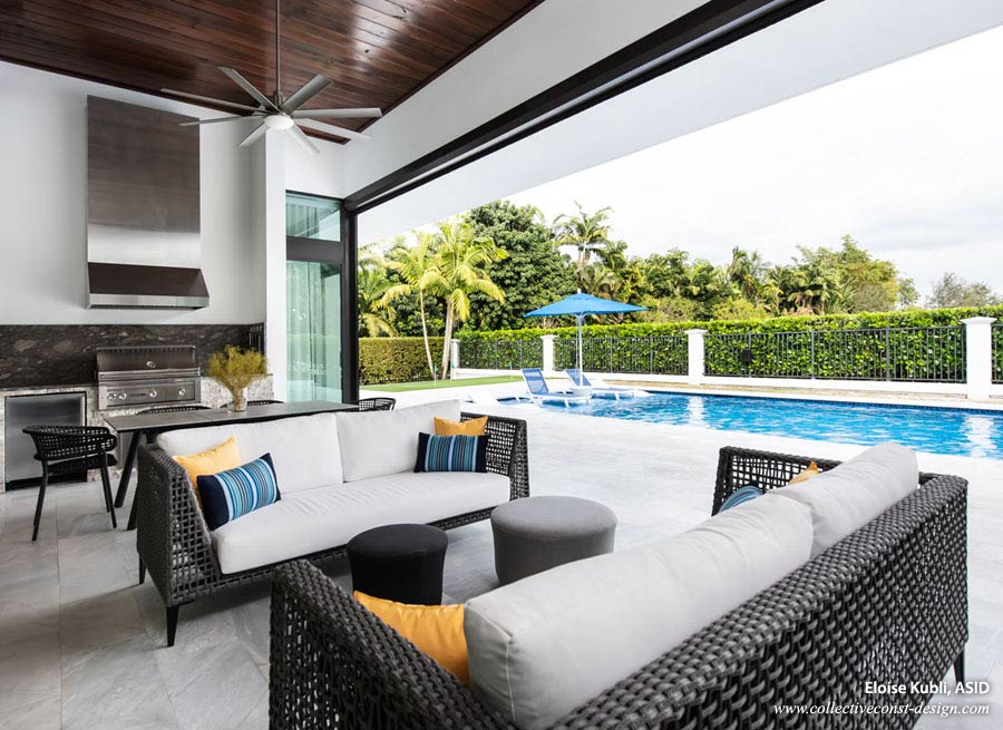 Outdoor kitchen and lounging area in patio of a modern custom home.