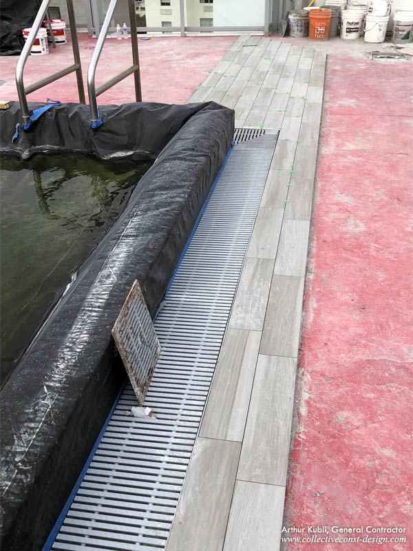 Detail shot of stainless steel drain covers and pool coping (protected).
