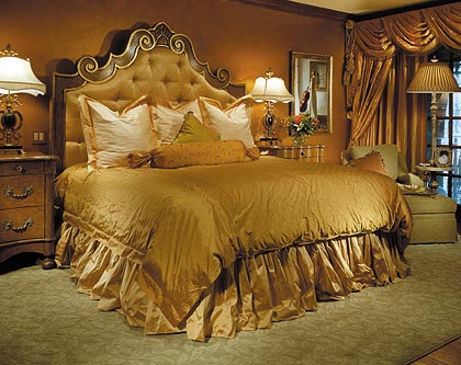 Plush and lustrous, beautiful custom bedding, window treatments, and warm earthy colors create a restful atmosphere the master bedroom.