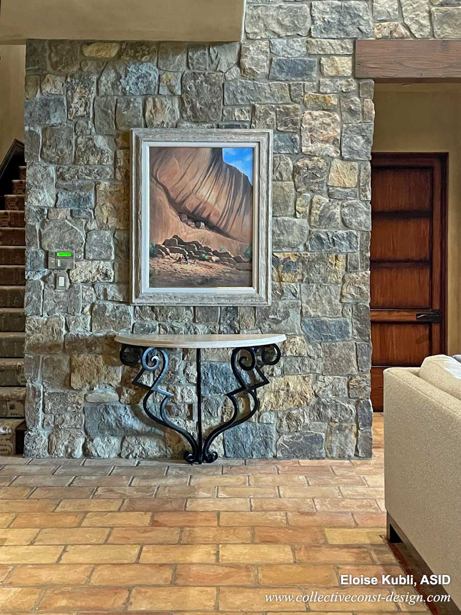 Foyer with custom Demi lune console, original oil artwork above. Antique French terra cotta floors and stone-clad walls. 