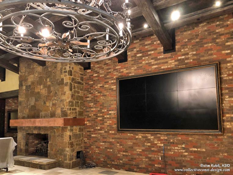 Great room under construction. Fireplace and chandelier, brick walls, flagstone floors all emplaced.